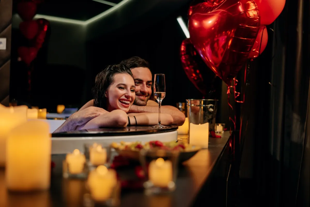 Para w jacuzzi wśród balonów w kształcie serc