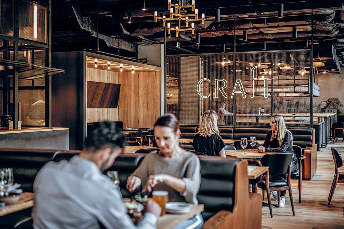 Interiér restaurace ve Vratislavi, hosté u baru