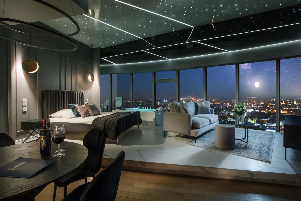Obývací pokoj apartmánu In The Sky s vířivkou u panoramatického okna